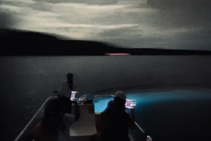 a man sitting next to a body of water