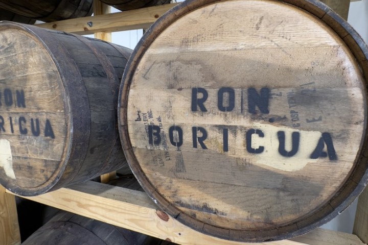 Two wooden barrels labeled 'Ron Boricua' on a wooden rack.